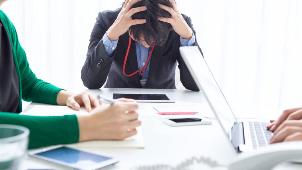 頭を抱える企業の人