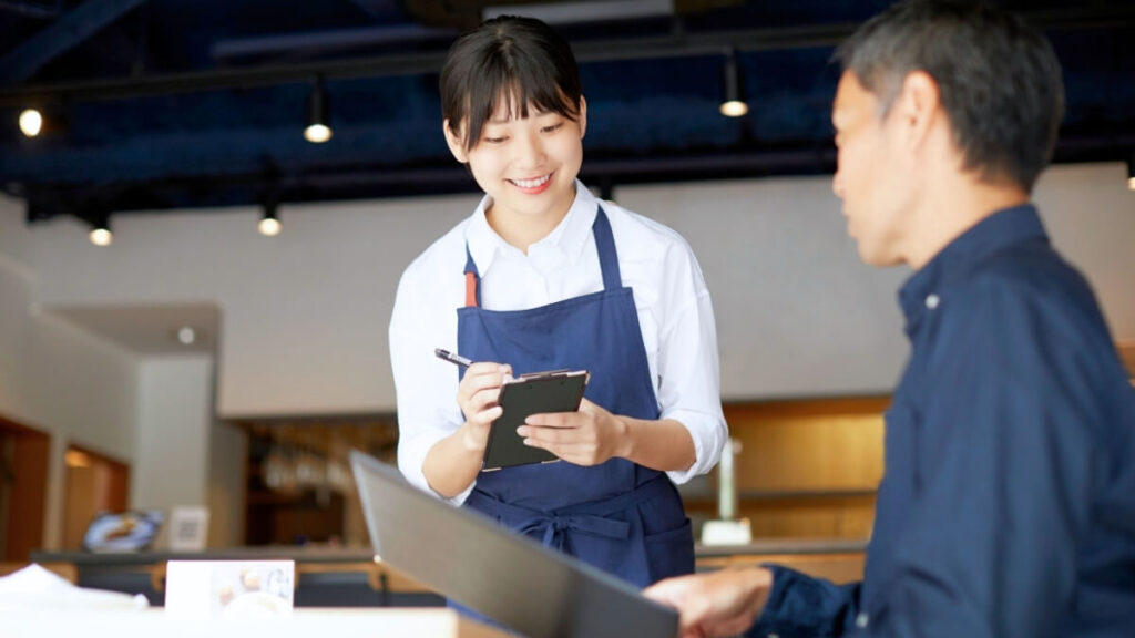 カフェで笑顔で接客している店員